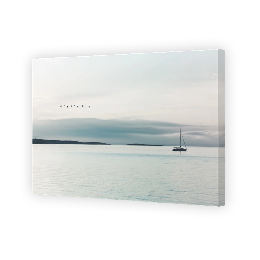 sail boat sails quietly in the ocean illuminated by a surreal light