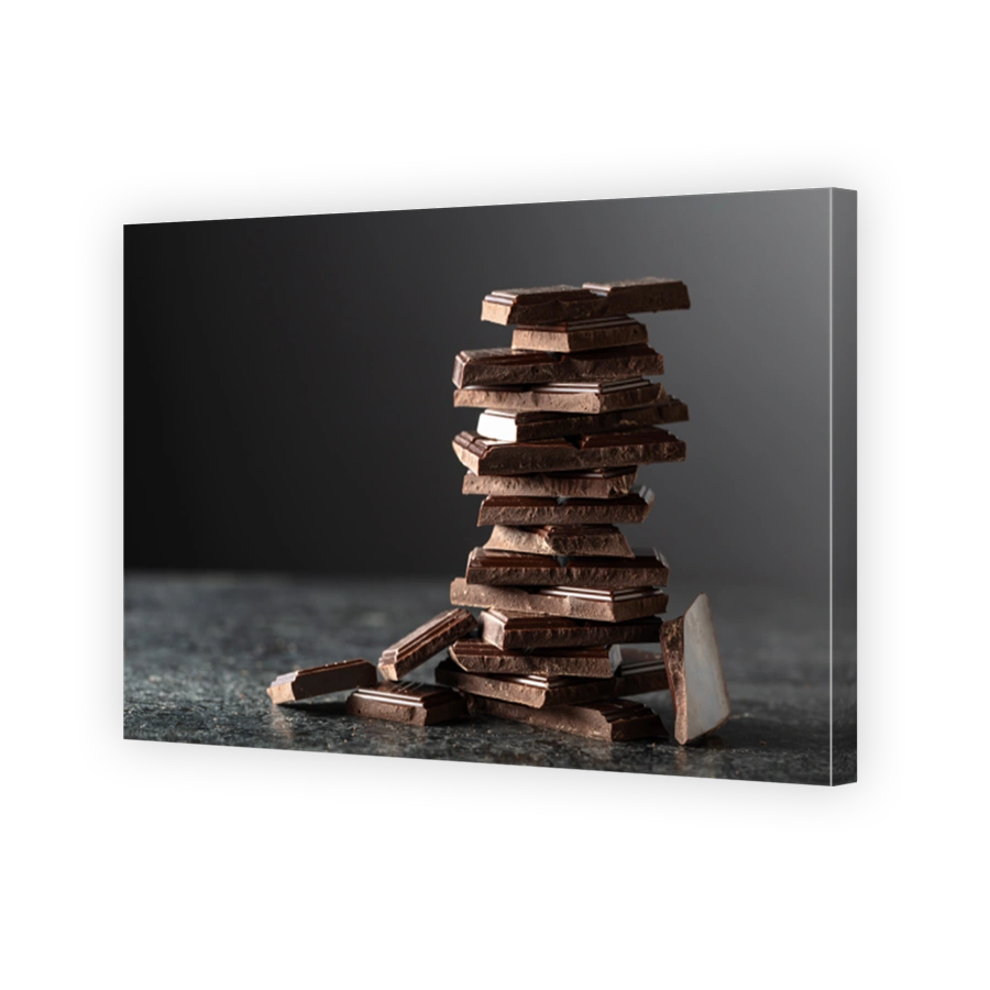 Broken bitter chocolate bar on a black background.