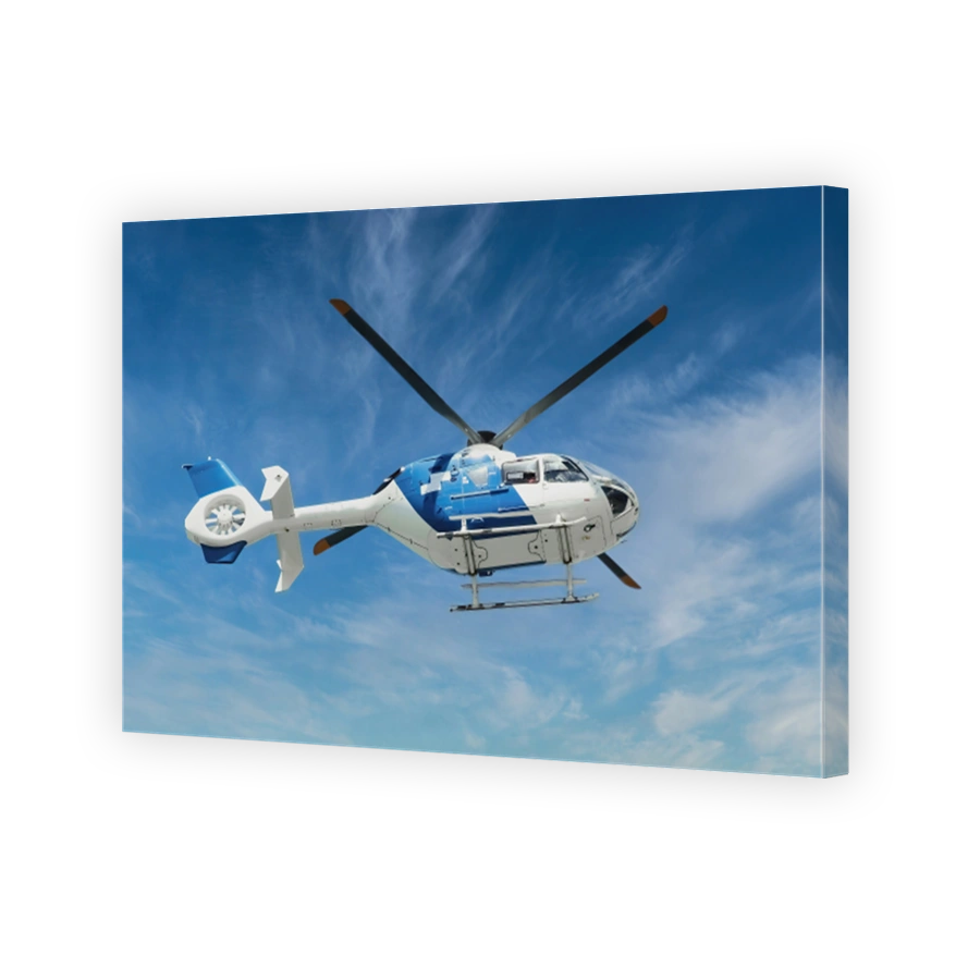 Blue and white air ambulance rescue helicopter flying mid-air against a blue sky background