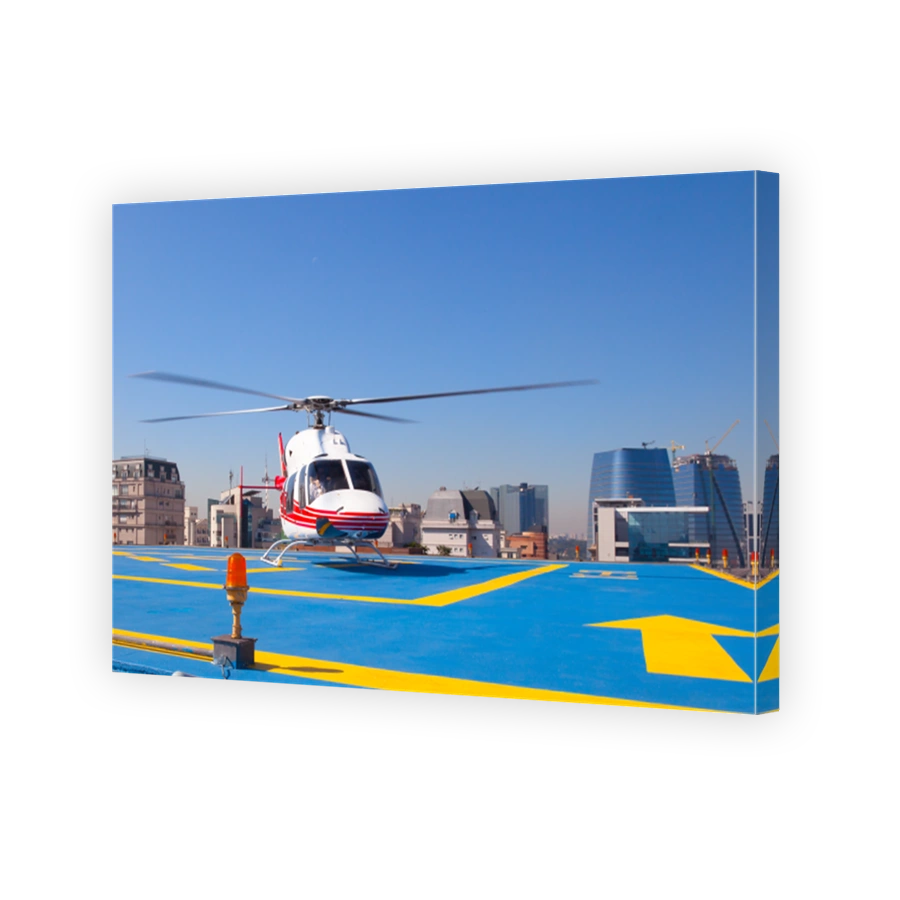 Helicopter sits on the helipad of a building.