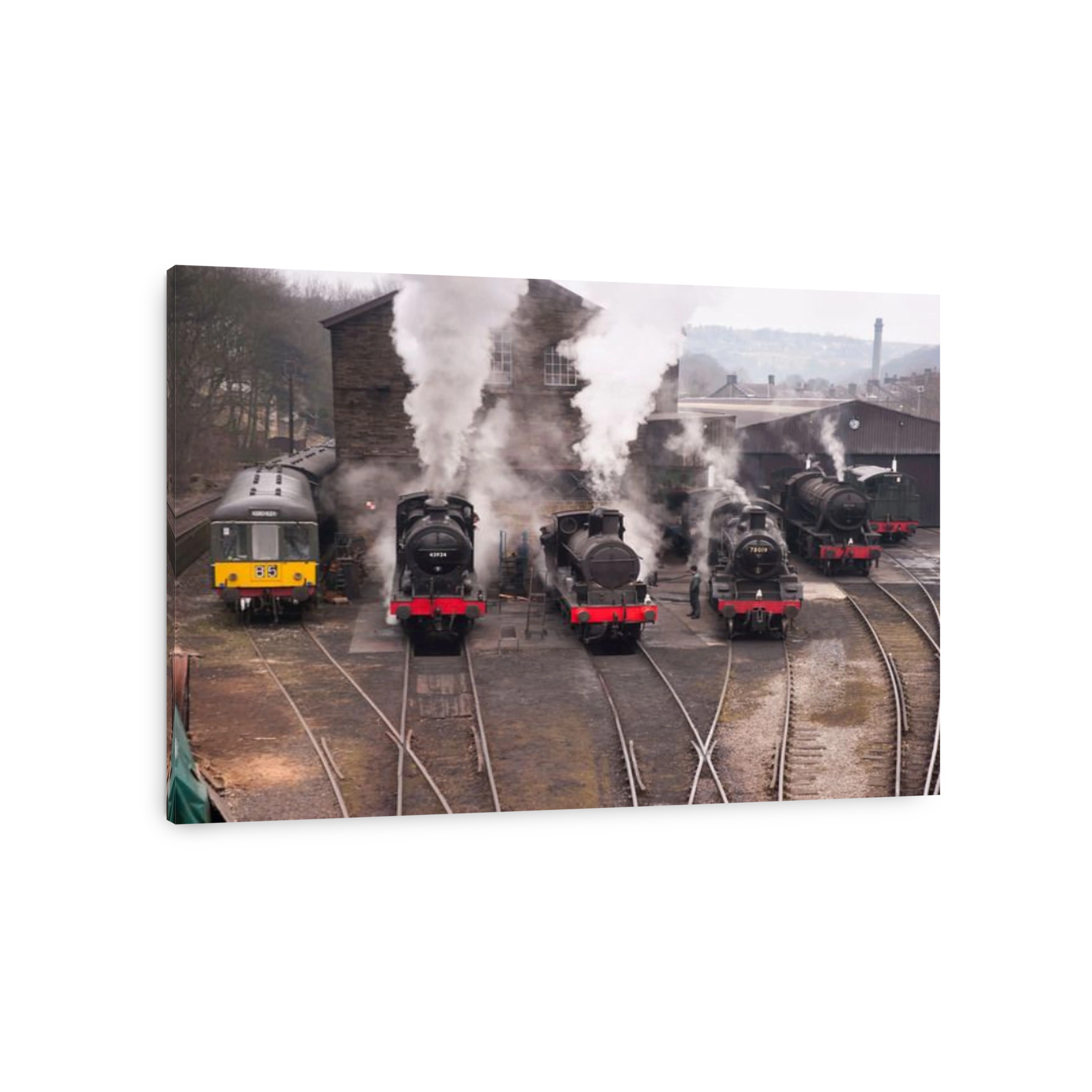 a row of steam locomotives and a classic 1960s diesel engine warming up prior to a gala day in Haworth