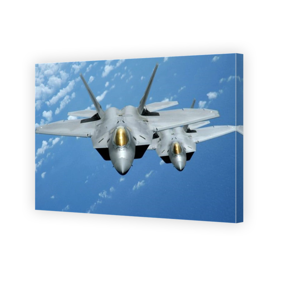 Two F-22 Raptors fly over the Pacific Ocean.