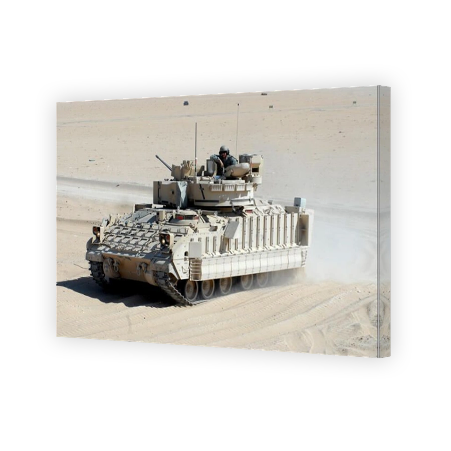 A soldier looks out of the top hatch of a Bradley Fighting Vehicle.