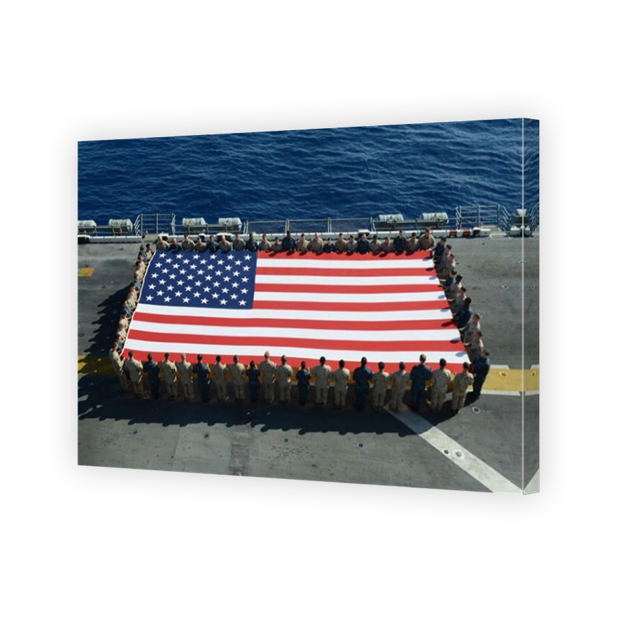 Sailors and Marines display the national ensign aboard USS Kearsarge.