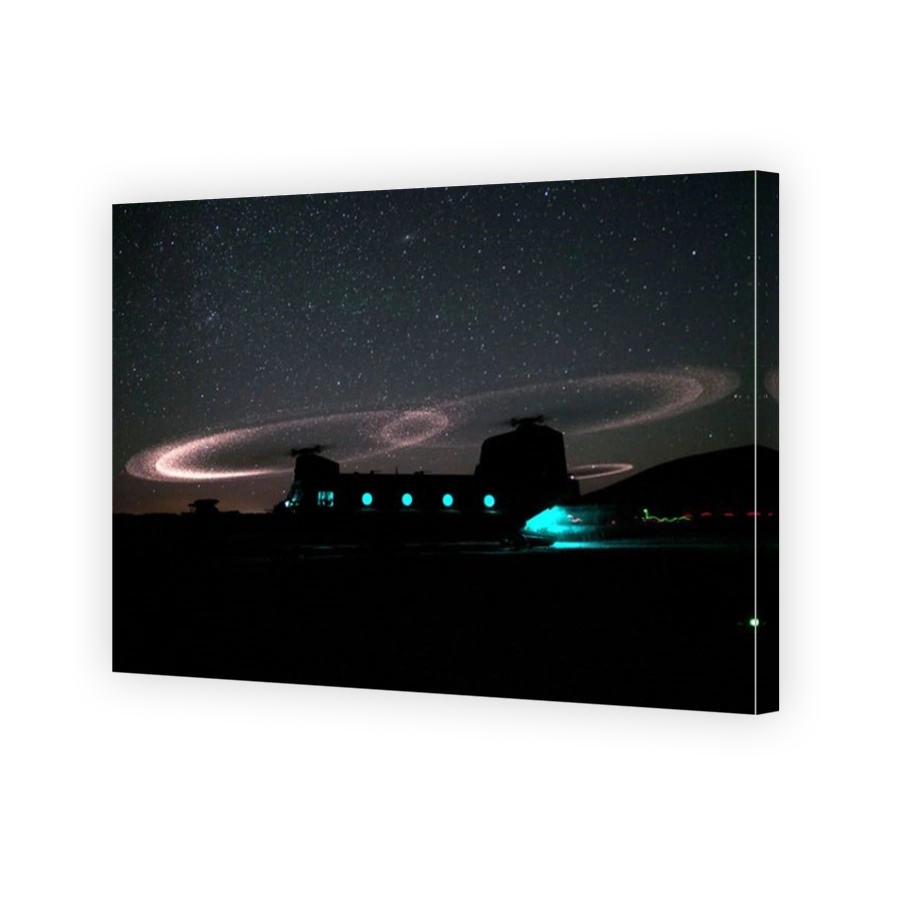 Dust lights up the rotors of a CH-47 Chinook helicopter.