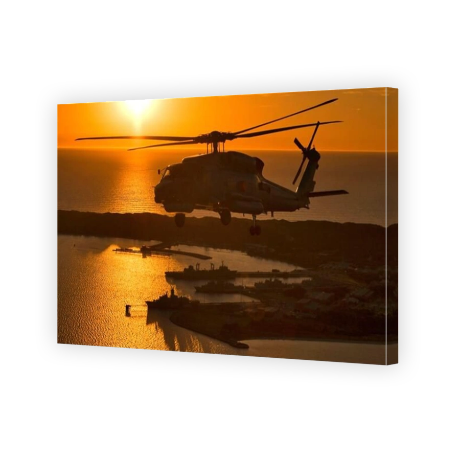 A Sikorski S70B Seahawk helicopter flying over Western Australia naval base of HMAS Stirling at sunset.