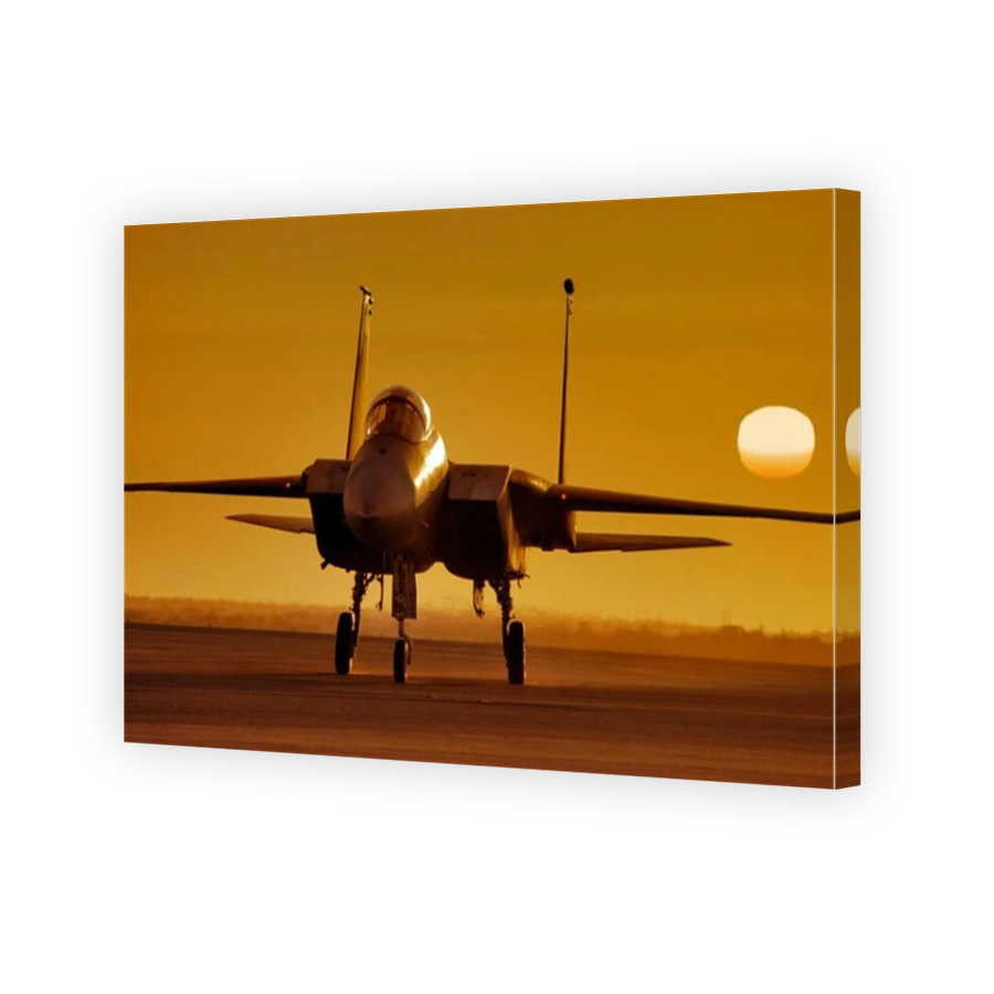 McDonnell-Douglas F15 Strike Eagle jet fighter at sunset, with the golden orb of the sun in the  background.
