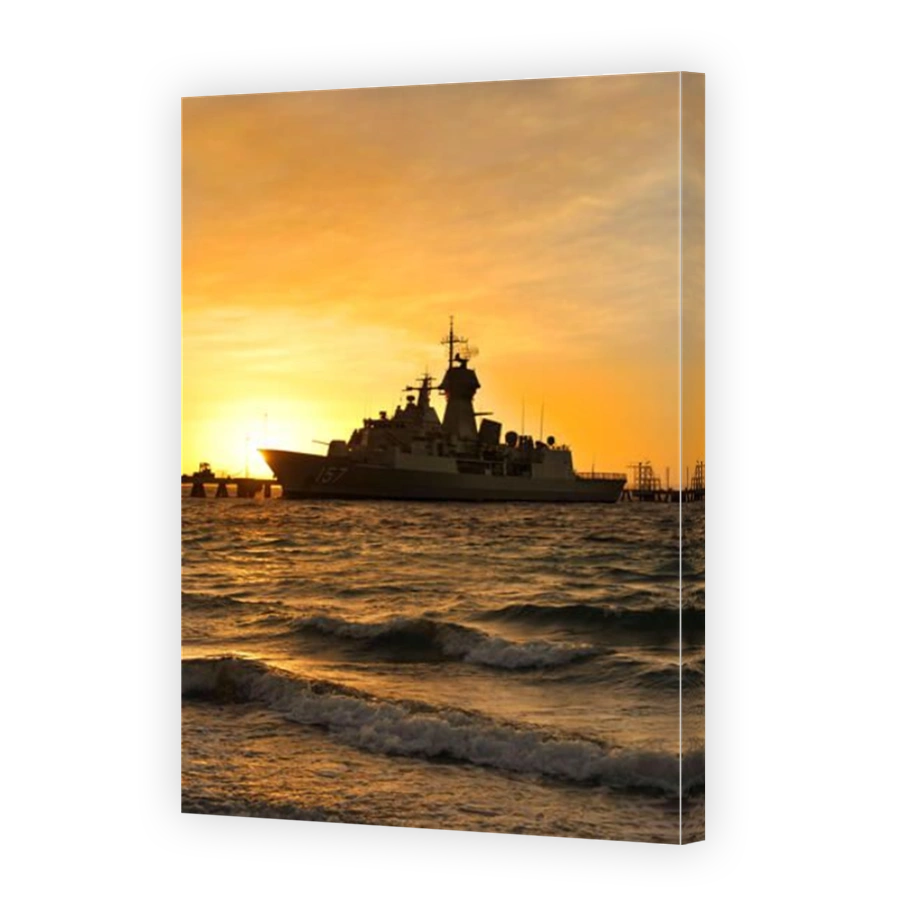 Dawn light silhouettes the Royal Australian Navy frigate HMAS Perth, at Ammunition Wharf, Garden Island naval base, Western Australia.