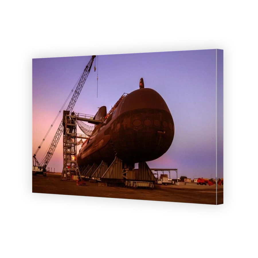 Pastel dawn illuminates an Australian Navy Collins Class diesel electric submarine undergoing service on dry land.