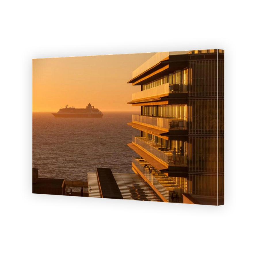 A cruise ship leaves Cádiz bay at sunset, while people enjoy the view from the terrace of the hotel "Parador de Cádiz Hotel Atla