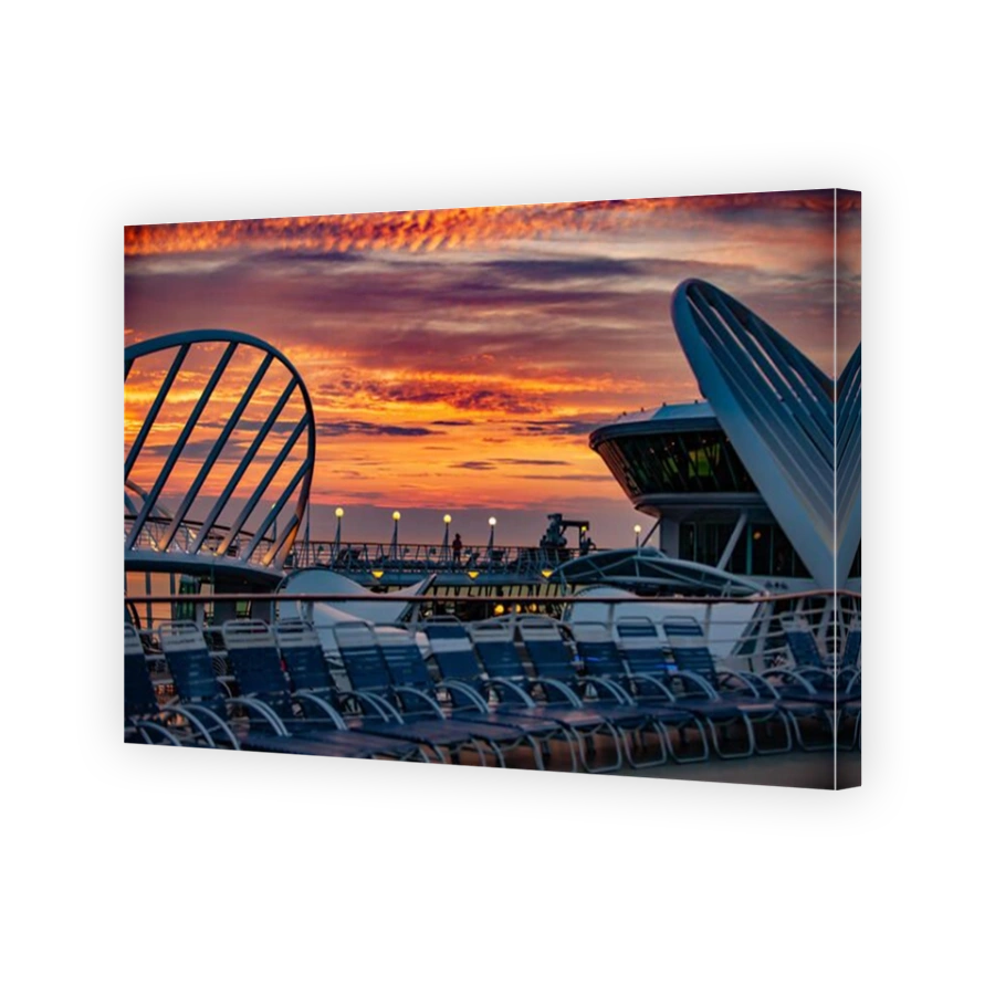 Sunset cruise ship - stunning orange yellow and red New England sunset from the deck of a cruise ship. Cruise ship deck chairs lined up.