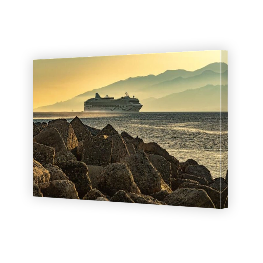The cruise ship crosses the Strait of Messina illuminated by the warm light of the sunset. Villa San Giovanni, Reggio Calabria, Calabria, Italy