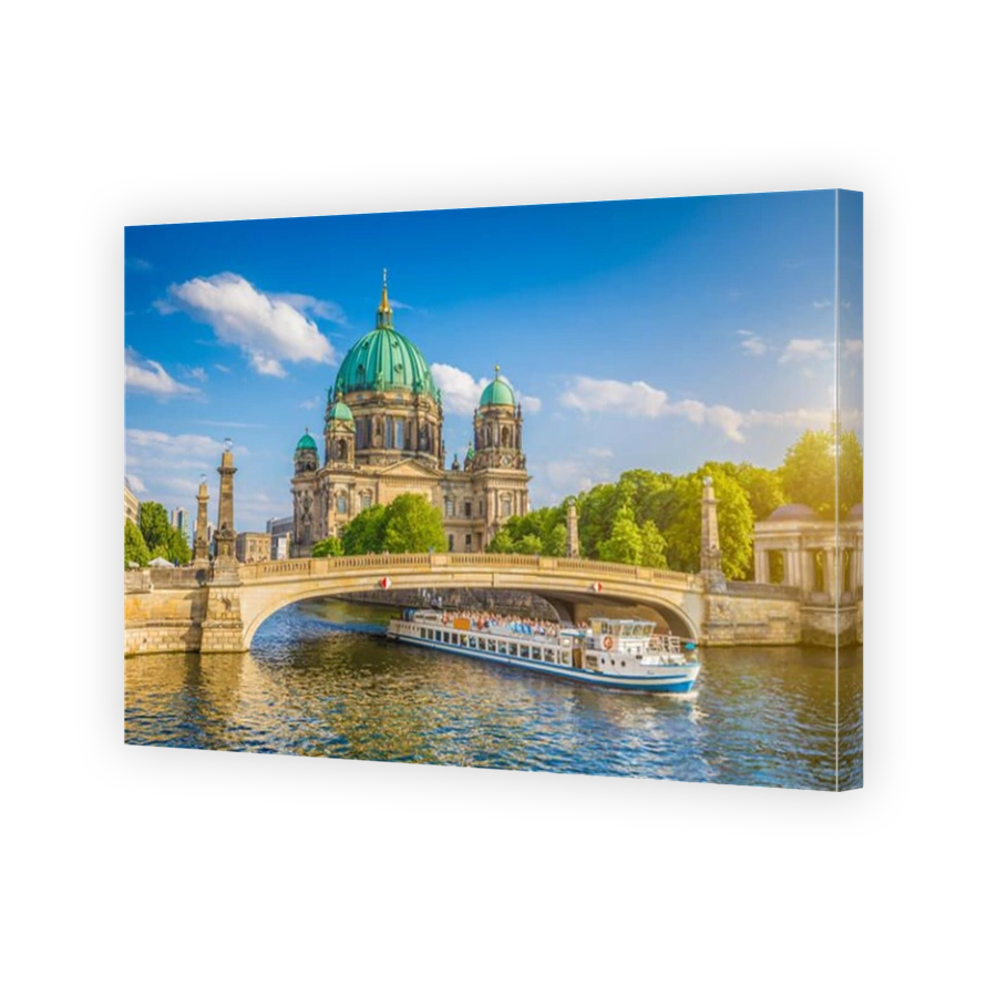Beautiful view of historic Berlin Cathedral (Berliner Dom) at famous Museum Island with ship passing Friedrichsbrucke bridge on Spree river at sunset